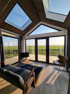 a living room with large windows and a couch at Arctic Exclusive Ranch in Kirkjubæjarklaustur