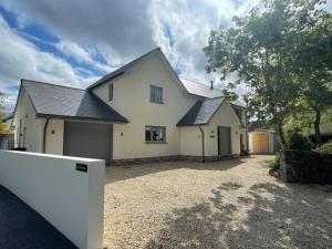 una casa blanca con una entrada delante de ella en Luxury Devon House, en Chulmleigh