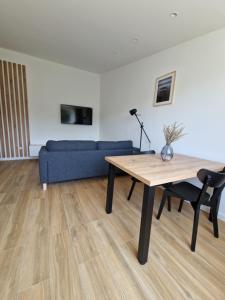 a living room with a table and a blue couch at Apartmani Maritimo in Seline
