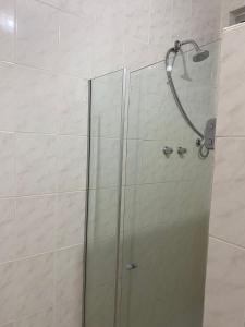 La salle de bains est pourvue d'une douche avec une porte en verre. dans l'établissement Quartinho Copacabana-Posto 5, à Rio de Janeiro