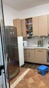 eine Küche mit einem Kühlschrank aus Edelstahl und einem blauen Stuhl in der Unterkunft Villa Claudia Relais in Mirto