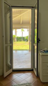 eine offene Glasschiebetür mit Blick auf einen Hof in der Unterkunft Villa Claudia Relais in Mirto