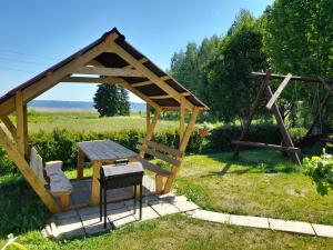Dvarči的住宿－viesu māja "Osmany"，木制凉亭配有桌子和长凳