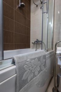 - Baño con toalla al lado de la bañera en Vila Palić Soba 1 lux, en Palić