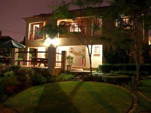 a house at night with a lawn in front of it at East View Guesthouse in Pretoria