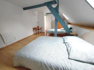 Un dormitorio con una cama y una escalera en una habitación en Gîte du Connétable, en Couville 1 foto más