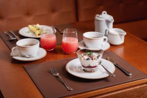 a table with plates of food and cups and utensils at 249 DESIGN HOTEL in Gramado