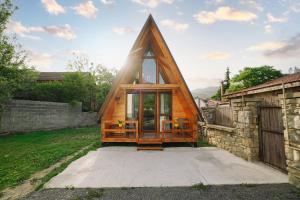 a frame house with a triangular roof with glass doors at Mtskheta Cabin in Mtskheta