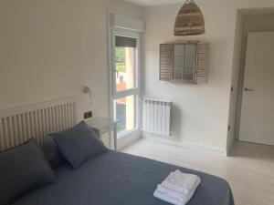 a bedroom with a blue bed and a window at Piso acogedor entre mar y montaña in Posada de Llanes