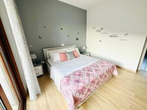 a small bedroom with a bed with pink pillows at SWEET HOME in Himare