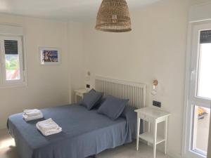 a bedroom with a blue bed with two towels on it at Piso acogedor entre mar y montaña in Posada de Llanes