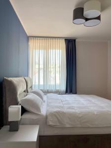 a bedroom with a large white bed with a window at Homely Stay Apartment 2 in Sankt Pölten