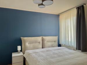 a blue bedroom with a bed and a blue wall at Homely Stay Apartment 2 in Sankt Pölten