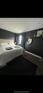 1 dormitorio con cama blanca y espejo en Studio 11, en Portstewart