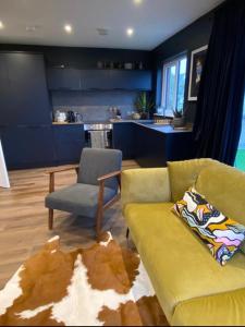 un soggiorno con divano giallo e sedia di Studio 11 a Portstewart