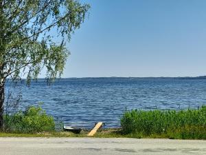 un barco sentado en la orilla de un gran lago en Laucinieki, en Mākoņkalns