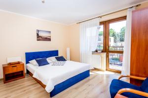 ブワディスワボボにあるWilla Krystynaのベッドルーム(青いベッド1台、大きな窓付)