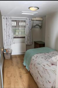 a bedroom with a bed and a window at The Snug At Kingfisher Cottage in Antrim
