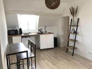 uma cozinha e sala de jantar com mesa e cadeiras em Appartement confort em Pacy-sur-Eure