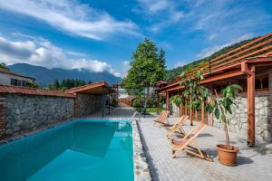 ein Haus mit einem Pool und zwei Stühlen in der Unterkunft Your home, Lagodekhi in Lagodechi