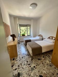 una camera d'albergo con due letti e una finestra di Appartamento Funtanedda - Affitti Brevi Italia a Triei