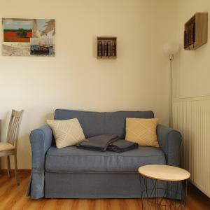 Ferienwohnungen Rügen-Glück في لوهم: غرفة معيشة مع أريكة زرقاء وطاولة