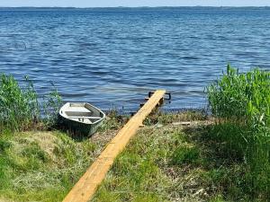 a boat sitting on the shore of a body of water at Laucinieki in Lipuški +3 photos