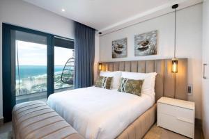 - une chambre avec un grand lit et une grande fenêtre dans l'établissement Lux Oceans 2 Bedroom Apartment in Umhlanga, à Durban