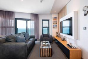 a living room with a couch and a table at Lux Oceans 2 Bedroom Apartment in Umhlanga in Durban