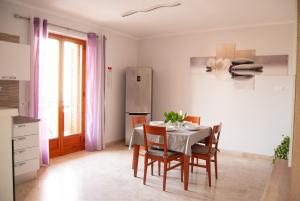 Una cocina y un comedor con mesa y sillas. en Casa Romualdo, en Monopoli