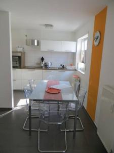 eine Küche mit einem Tisch und Stühlen im Zimmer in der Unterkunft Ferienwohnung BELVEDERE Orange in Rust