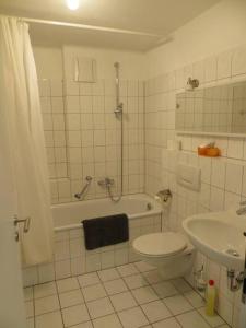 La salle de bains est pourvue de toilettes, d'une baignoire et d'un lavabo. dans l'établissement Ferienwohnung BELVEDERE Orange, à Rust