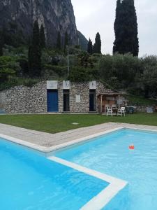 a large swimming pool in front of a stone house at L'angolo di pace e relax del lago di Garda in Riva del Garda