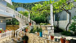 um jardim com vasos de plantas numa parede de pedra em Jico Travel - Villa Samuel em Vlorë