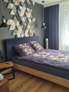 a bedroom with a bed with a geometric wall at Apartament Małopanewska Wrocław Centrum in Wrocław