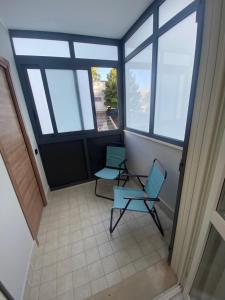 2 sillas sentadas en una habitación con ventanas en Casa Giuly, en Nápoles