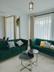 a living room with a green couch and a table at Sky Nest Grey point 306 in Kericho