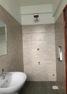 y baño con lavabo, aseo y espejo. en Sky Nest Grey point 306, en Kericho