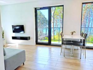 a living room with a table and a couch at SEA & YOU Apartament z widokiem na morze - Dwie Sosny in Ustronie Morskie