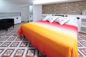 Mori Carretti Tamburelli في إيسبيكا: غرفة نوم مع سرير ملون ومدفأة