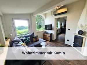 een woonkamer met een bank en een open haard bij Ferienhaus Rothsee-Oase ideale Ausgangslage mit tollem Ausblick, Sauna und privatem Garten in Roth