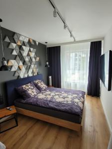 a bedroom with a bed in a room with a window at Apartament Małopanewska Wrocław Centrum in Wrocław