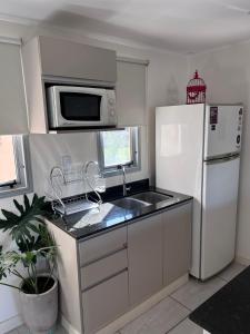 a kitchen with a white refrigerator and a sink at Andes Suites Premium in Salta