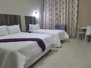 una camera d'albergo con due letti e un tavolo di Conmilla Guest House and Conference Venue a Berea Hills