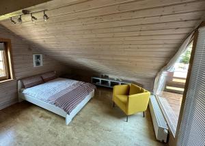 ein Schlafzimmer mit einem Bett und einem gelben Stuhl in der Unterkunft FeWo Wardersee 