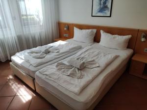 a large white bed with two towels on it at Ferienwohnung Achterwasser in Dewichow