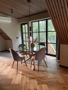 a dining room with a table and chairs and windows at Heinaläku puhkemaja loft in Paope