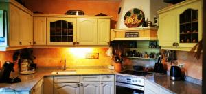 uma cozinha com armários brancos e um forno com placa de fogão em Haus Wagner em Schiltach
