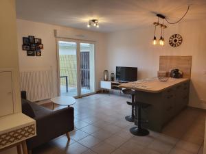 a kitchen and living room with a couch and a table at RESIDENCE LE DOMAINE DE MARTHIAS in Le Teich