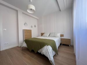 - une chambre avec un lit et une couverture verte dans l'établissement Cedemar 2, à Cedeira